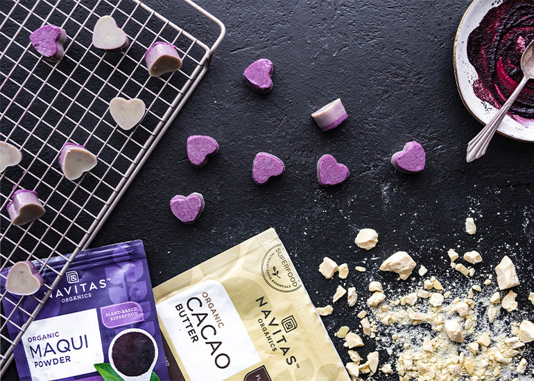A cooling rack topped with white chocolate maqui peanut butter heart candies made with Navitas Organics Cacao Butter and Maqui Berry Powder