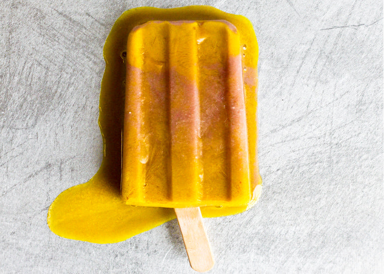 A single pomegranate turmeric popsicle made with Navitas Organics Turmeric Powder and Pomegranate Powder.