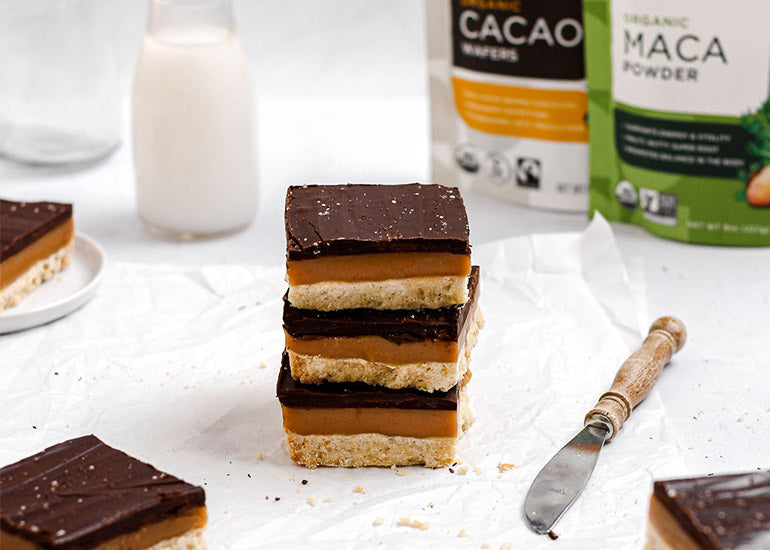 A stack of millionaire's shortbread bars made with Navitas Organics Cacao Wafers and Maca Powder.