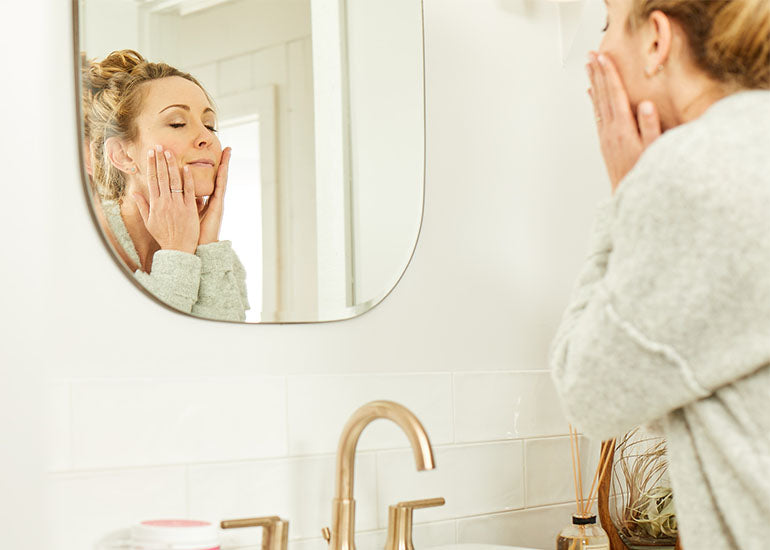 A woman doing her beauty regimen in the bathroom.