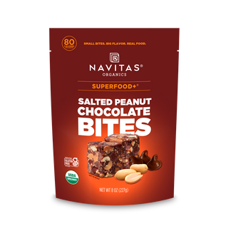 Navitas Organics Superfood+ Salted Peanut Chocolate BITES with dark chocolate-covered salted peanuts blended into bite-sized pieces on packaging against a white background.