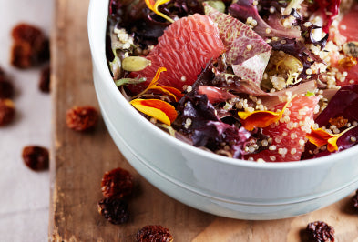 A bowl of oatmeal with berries, nuts, and seeds