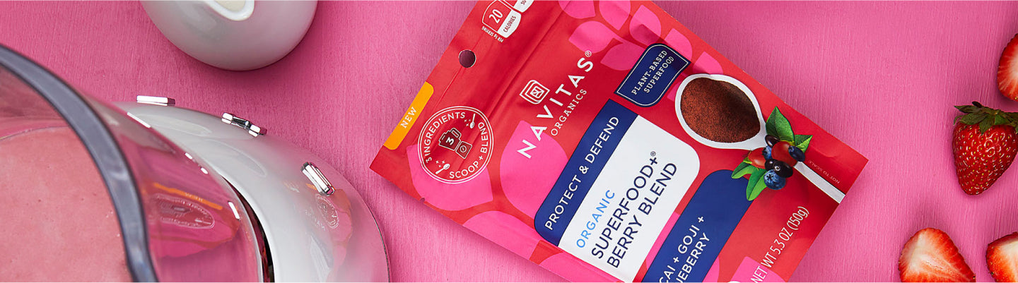 Package of Superfood Berry Blend on a counter with a blender and fresh fruit.