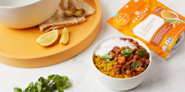 Navitas Organics Turmeric Powder by a plate of food