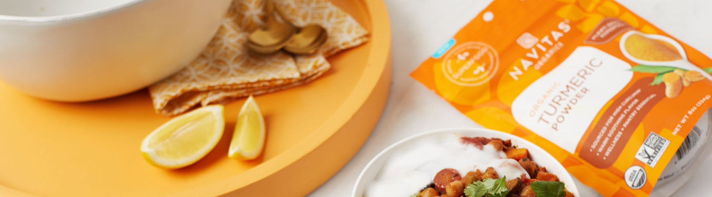 Navitas Organics Turmeric Powder by a plate of food